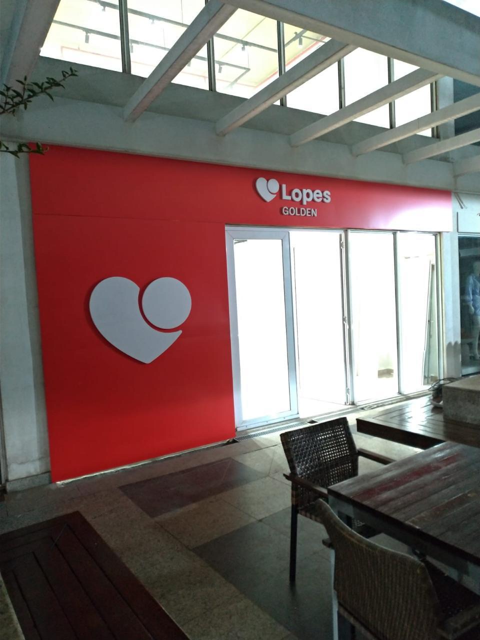 Fachada em ACM vermelho com logotipo em relevo da Lopes Golden